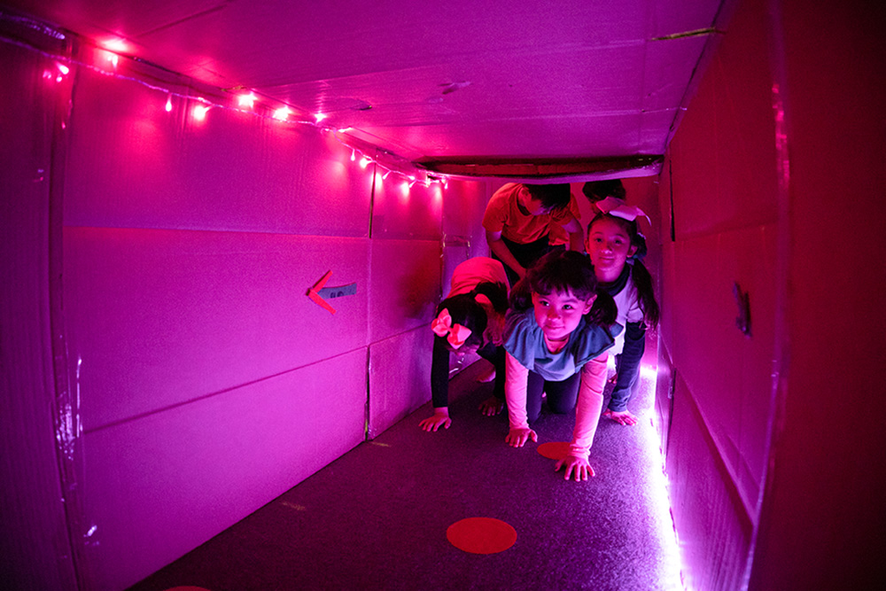 一群小孩爬进一个纸板隧道。