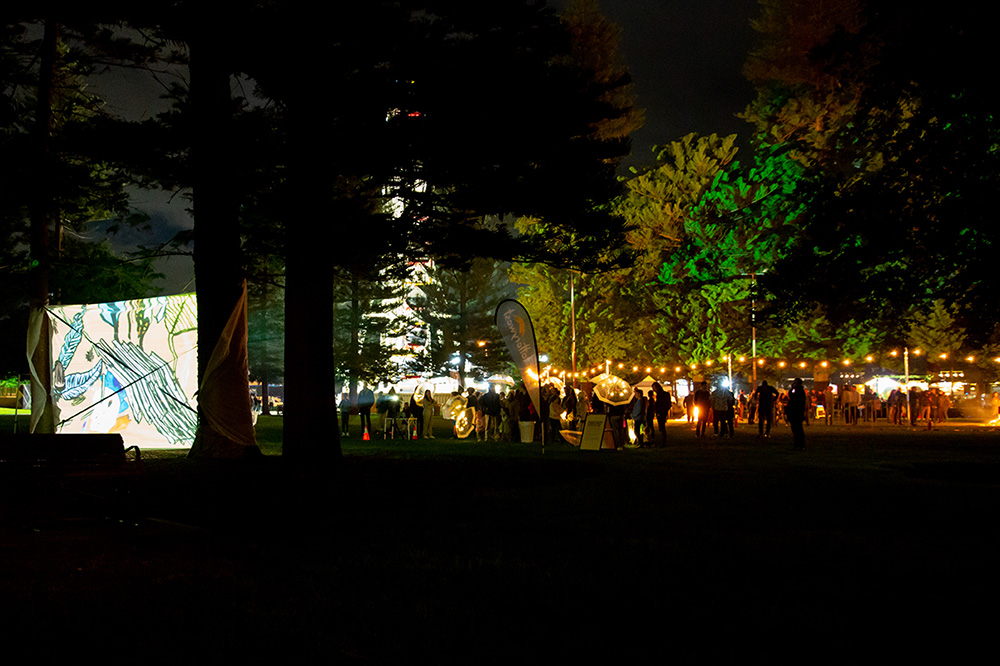 夜晚公园里观看投影的人群。
